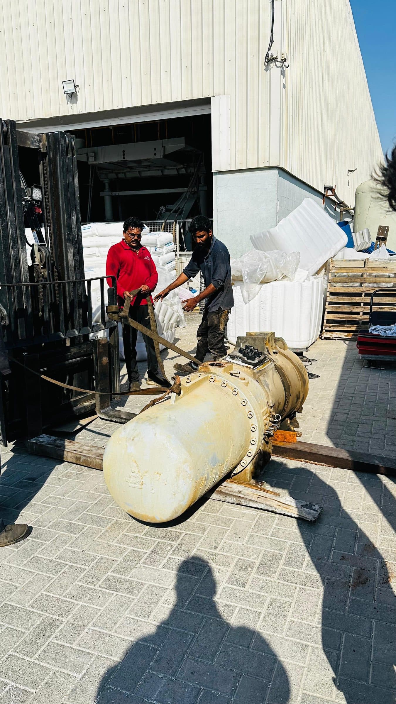Technicians beside the screw compressor on the yard