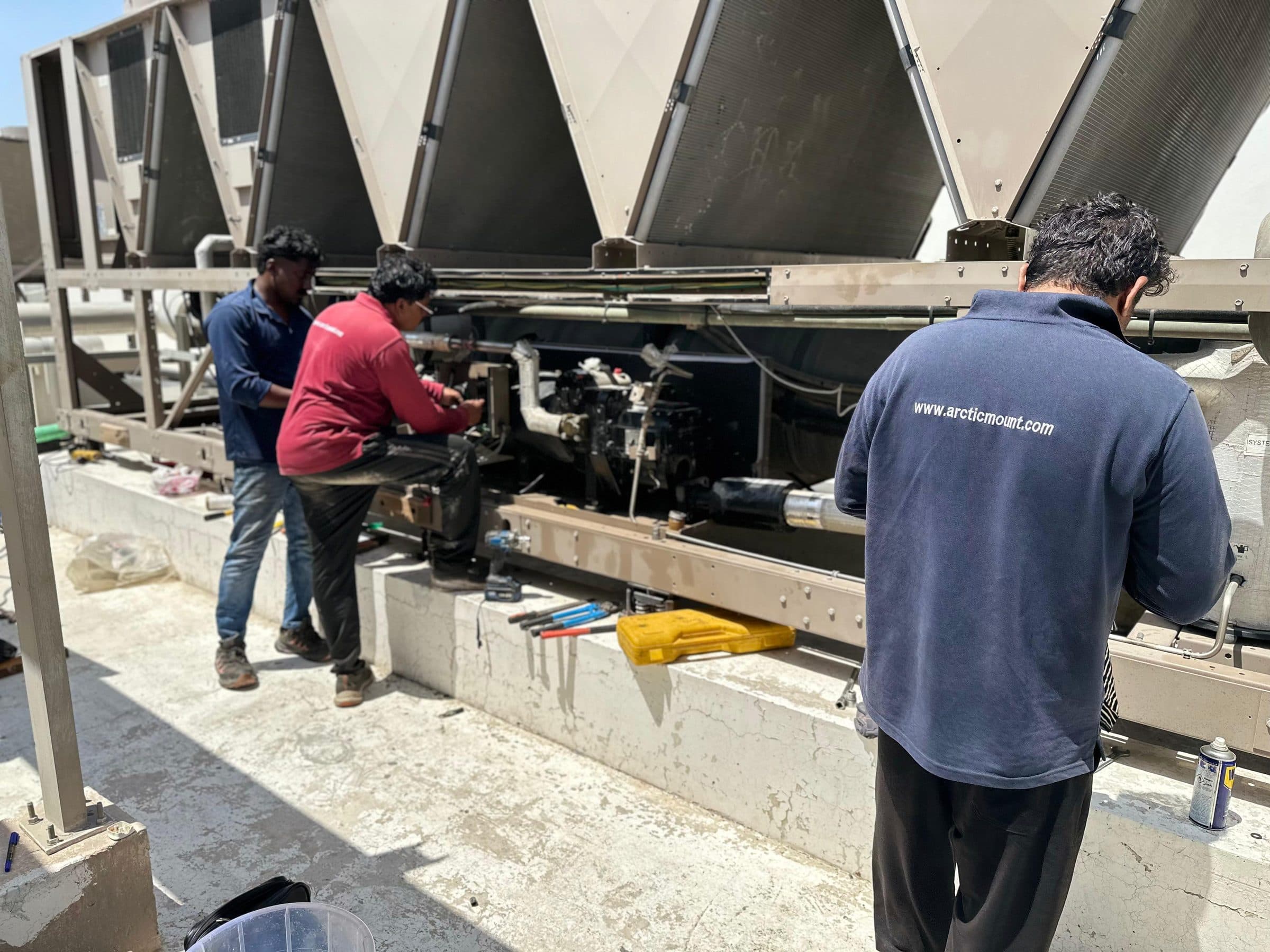 Technicians working together on the chiller compressor