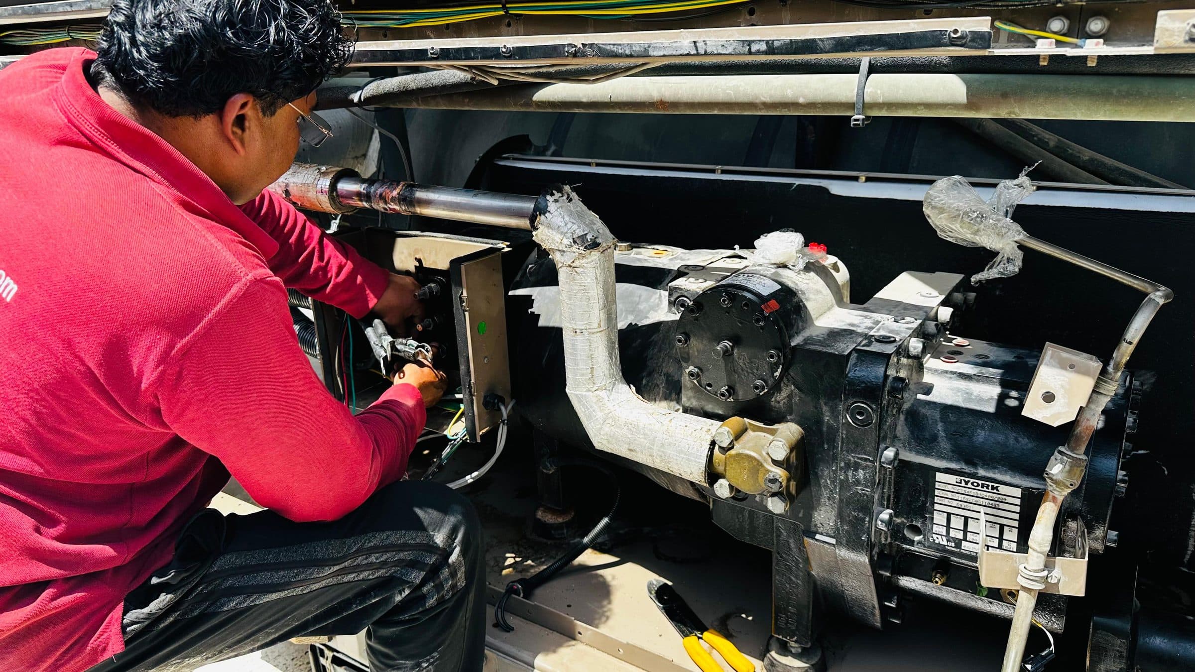Arctic Mount technician servicing a York screw compressor on a rooftop chiller